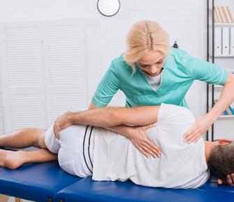 woman massaging mans back physical therapist
