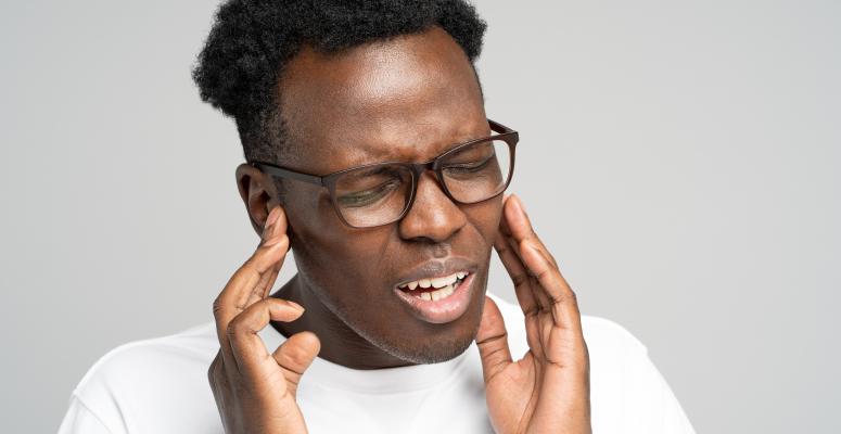 black man suffering from tinnitus